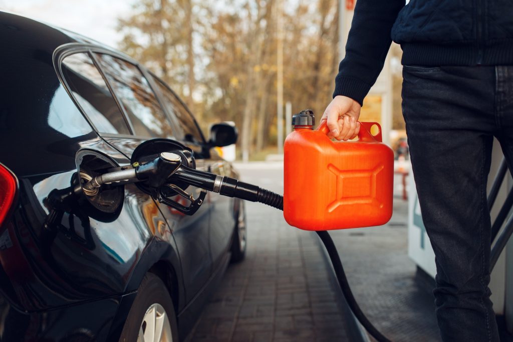 Man holding canister on gas station, fuel filling